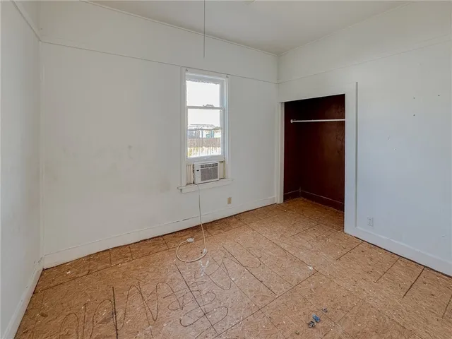 an empty room with windows and closet