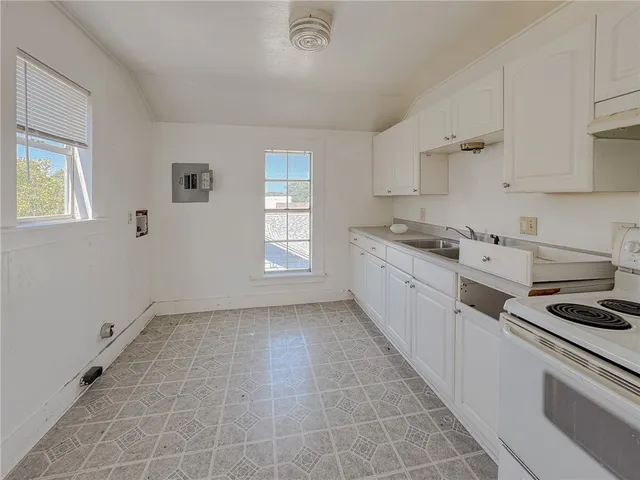 a kitchen with a sink a stove cabinets and counter space
