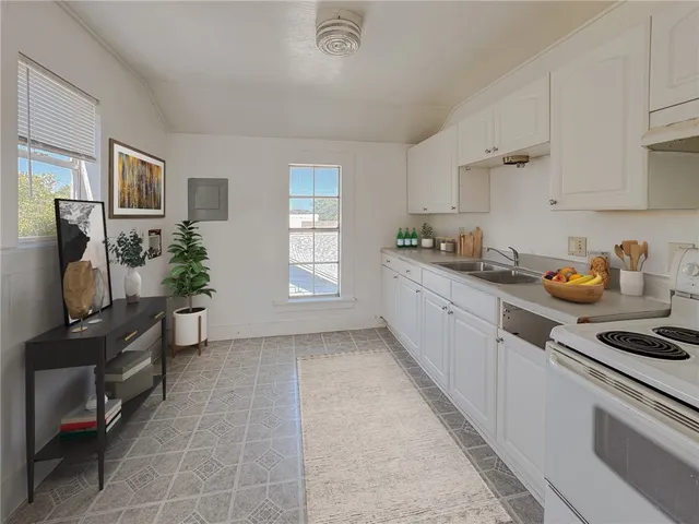 a kitchen with a sink a stove and cabinets