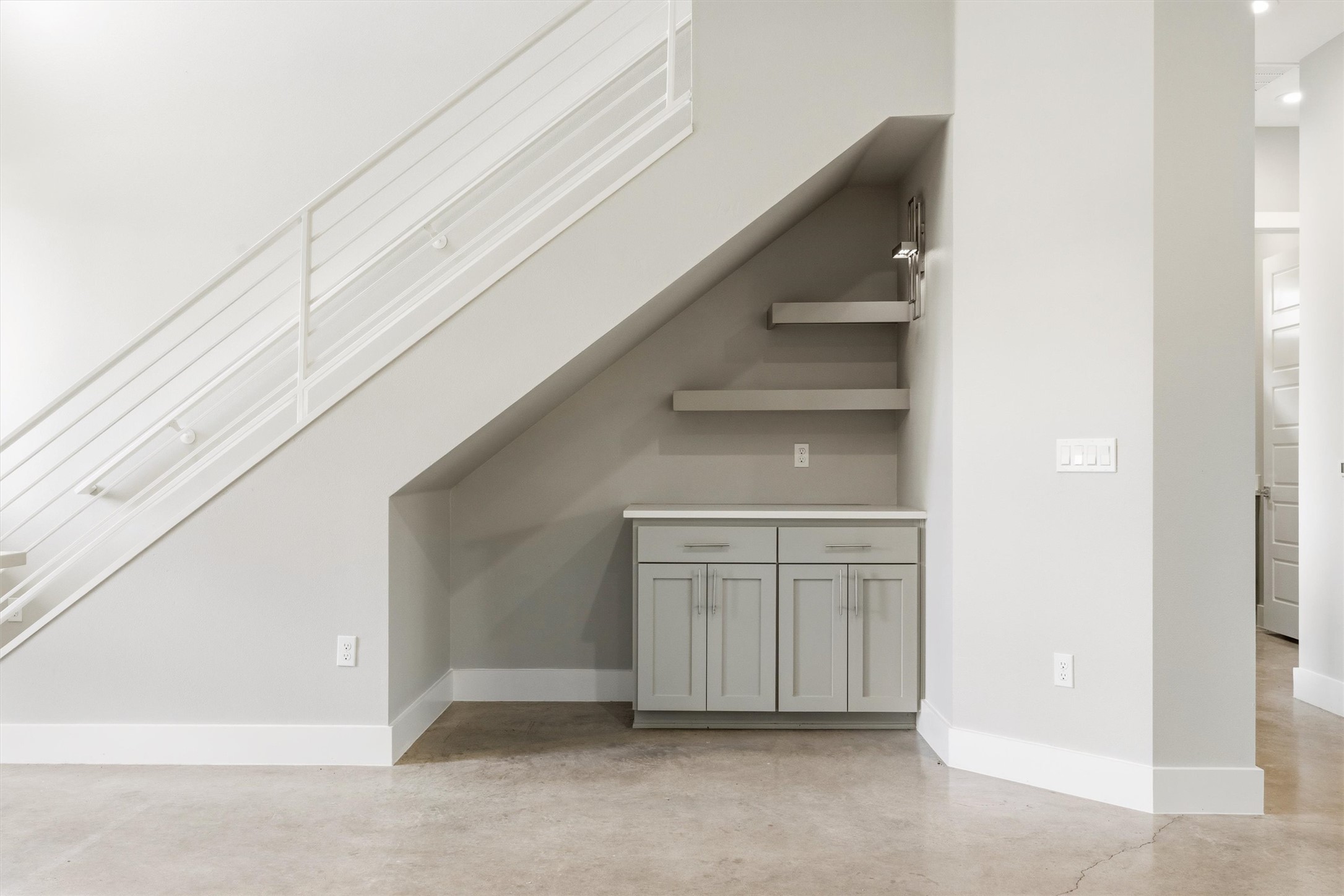 1210 Stobaugh Street, Unit B Austin, TX 78757 - Photo 31 of 40 Beneath a contemporary staircase, a custom-built cabinet with floating shelves offers practical storage.