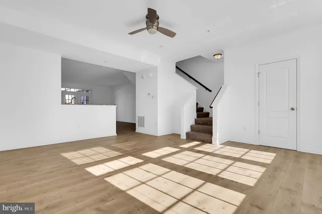 a view of a big room with wooden floor and stairs