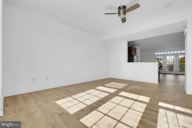 a view of a big room with wooden floor and windows