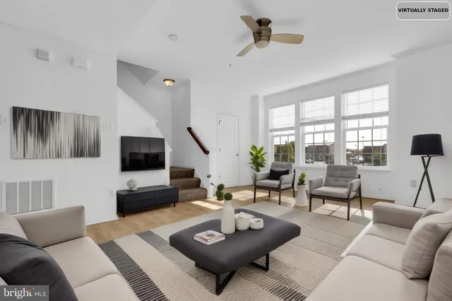 a living room with furniture a flat screen tv and a large window