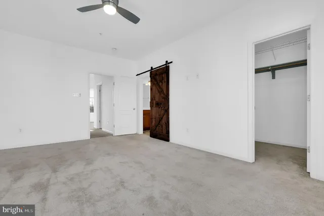 an empty room with closet and windows