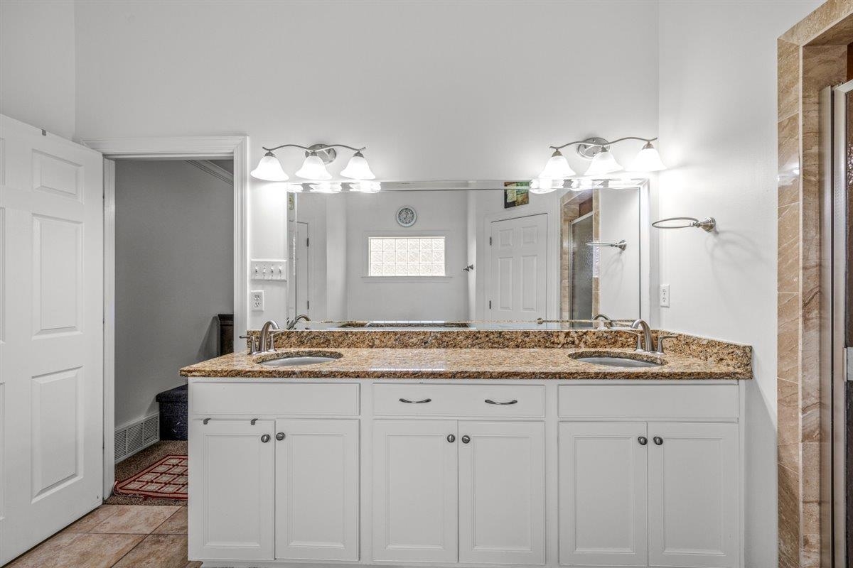 744 Southern Home Road Collierville, TN 38017 - Photo 10 of 24 Bathroom featuring a double vanity with a stone countertop, dual undermount sinks, and white cabinetry