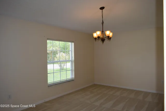 a view of a chandelier fan and window in a room