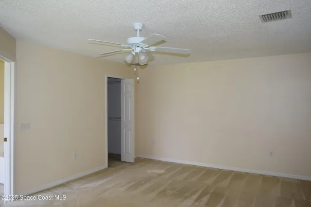 an empty room with a ceiling fan and a window