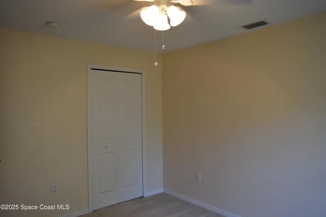 a view of a chandelier fan and hardwood floor