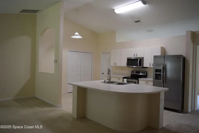 a kitchen with kitchen island a refrigerator stove a sink and a microwave