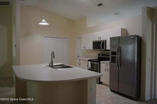 a kitchen with a refrigerator and a stove top oven