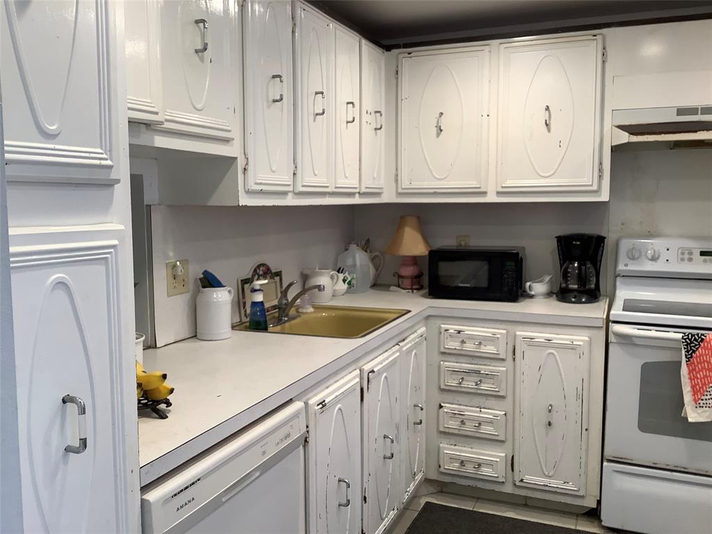 2300 Northeast 1st Lane, Unit 107 Boynton Beach, FL 33435 - Photo 2 of 26 a kitchen with granite countertop white cabinets and white appliances