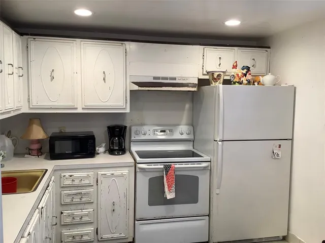 a kitchen with appliances cabinets and a sink