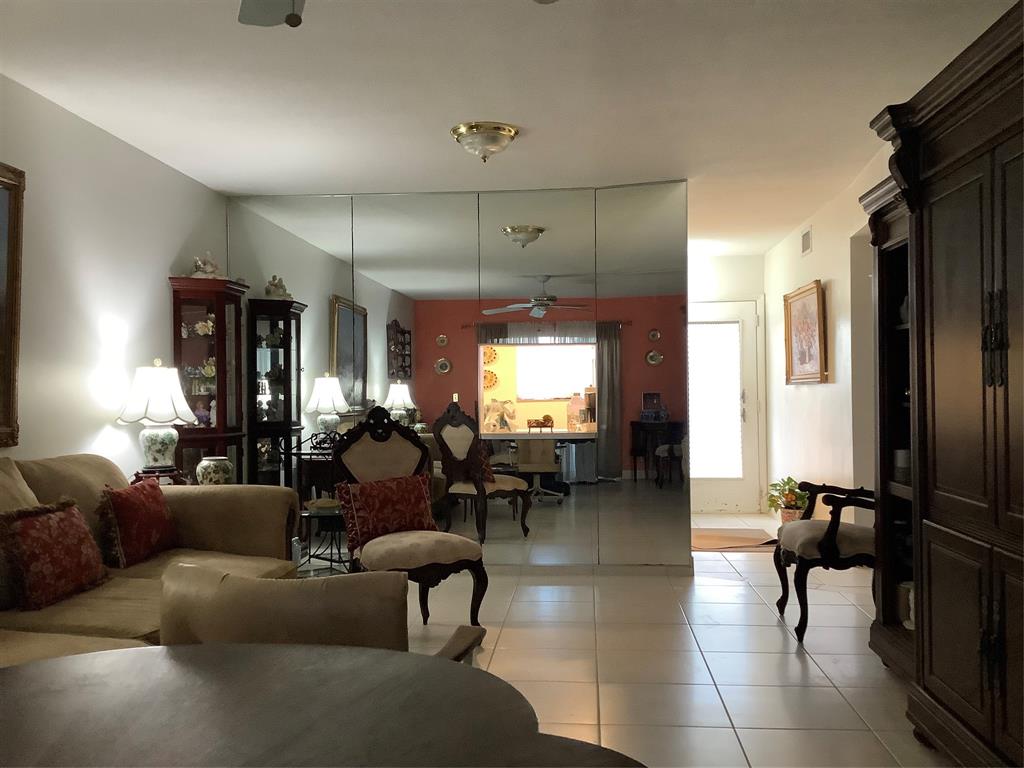 2300 Northeast 1st Lane, Unit 107 Boynton Beach, FL 33435 - Photo 8 of 26 a living room with furniture a large window and a chandelier