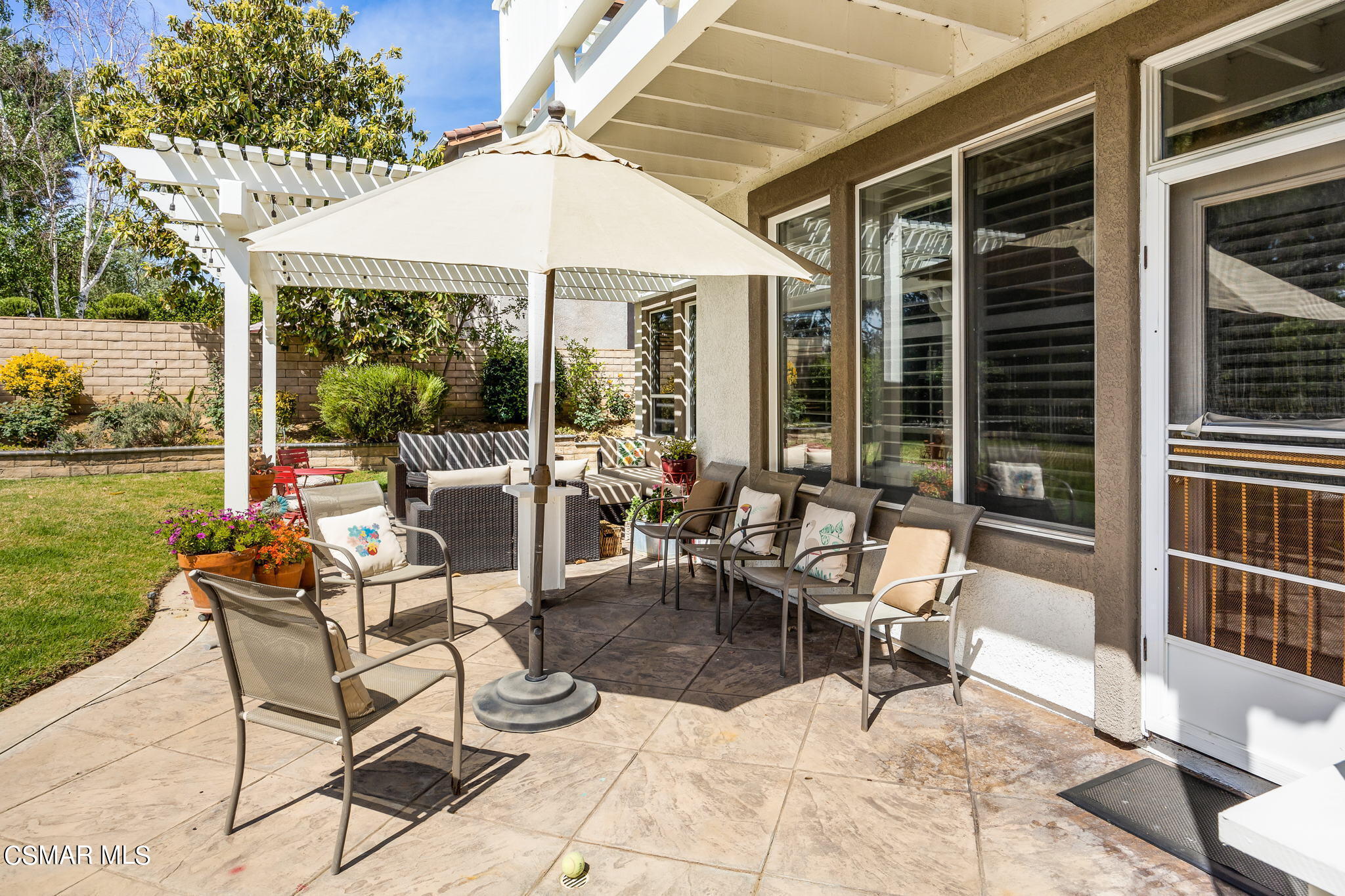388 Woodland Road Simi Valley, CA 93065 - Photo 51 of 62 a view of a patio with a dining table and chairs under an umbrella