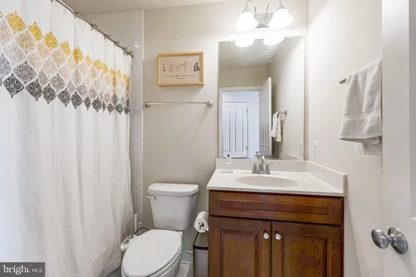 a bathroom with a sink vanity mirror and toilet