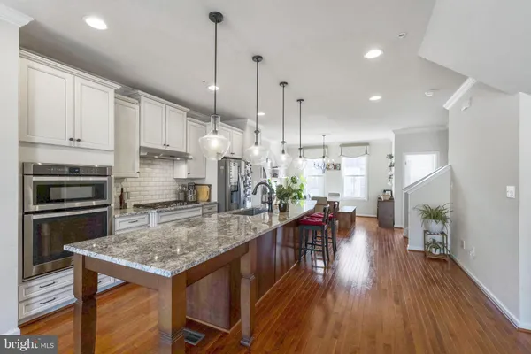 a kitchen with a table chairs refrigerator and microwave