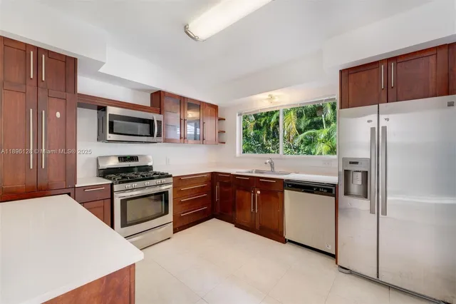 a kitchen with stainless steel appliances granite countertop a refrigerator stove microwave and sink