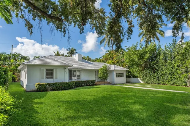 a front view of a house with a garden and yard