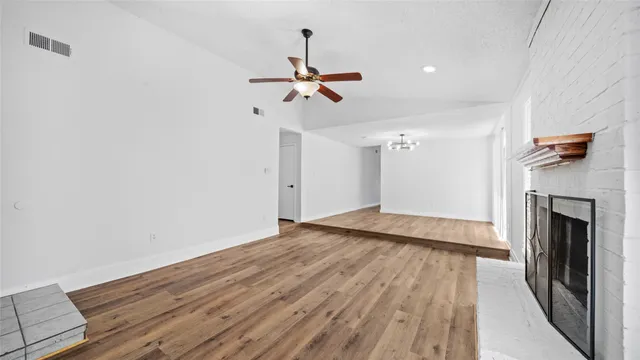 a view of a livingroom with wooden floor and a ceiling fan