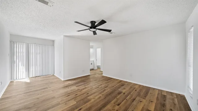 a view of a big room with wooden floor and windows in a room