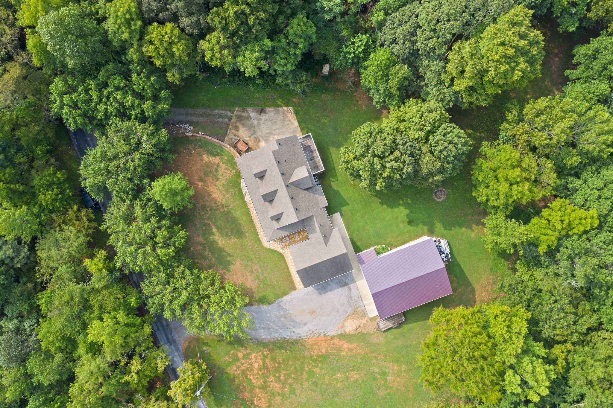 an aerial view of a house with outdoor space and a lake view in back
