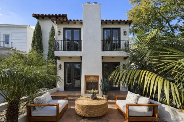 a view of a patio with couches table and chairs and potted plants