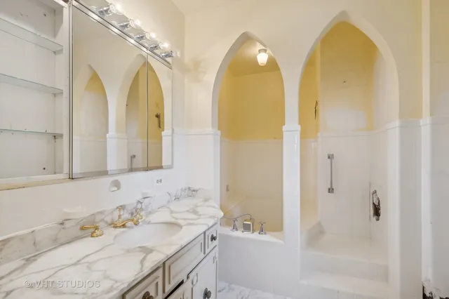 a bathroom with a granite countertop bathtub a sink and a mirror