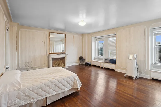 a spacious bedroom with a bed and wooden floor