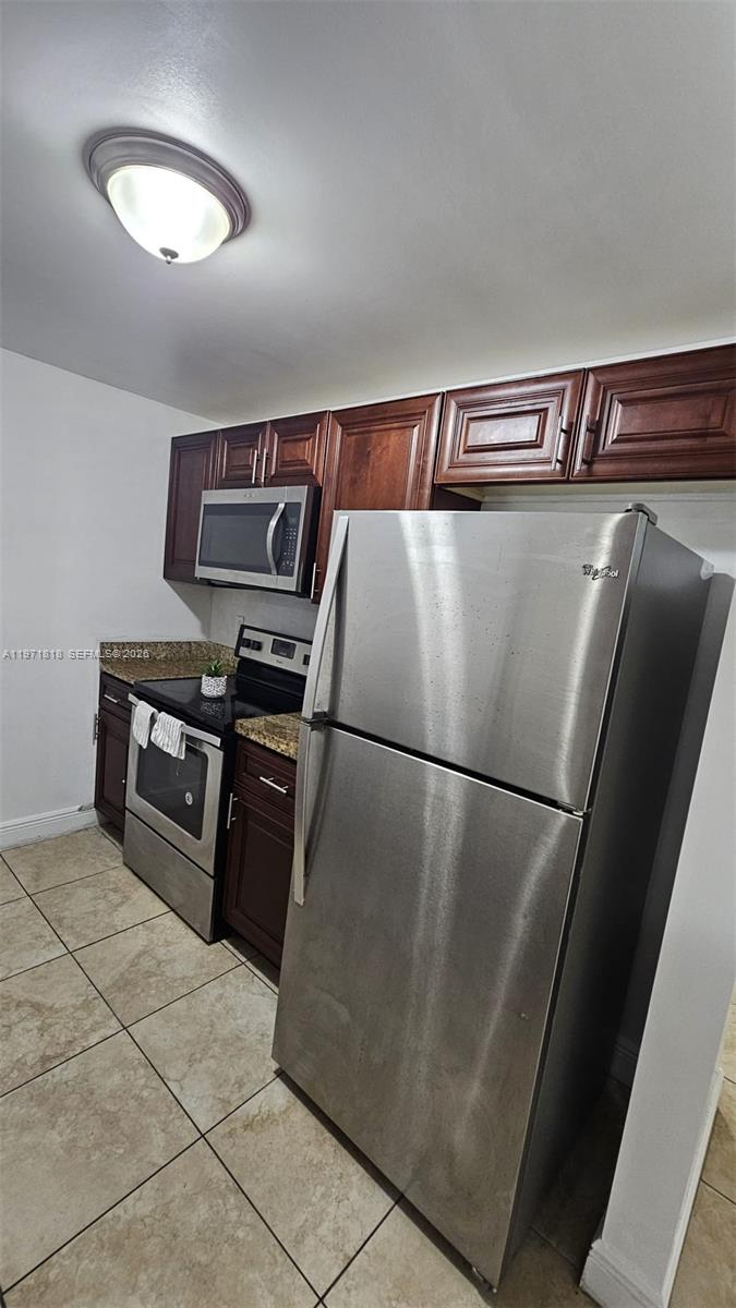 535 Northwest 19th Street, Unit 369 Miami, FL 33136 - Photo 17 of 26 a view of a refrigerator in kitchen and an empty room