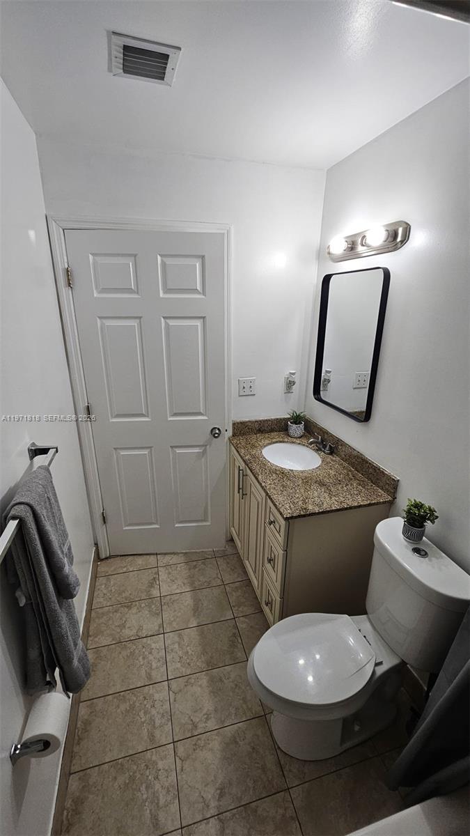 535 Northwest 19th Street, Unit 369 Miami, FL 33136 - Photo 19 of 26 a bathroom with a toilet a sink and mirror