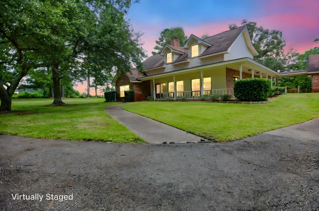 a view of a big house in a big yard with large trees