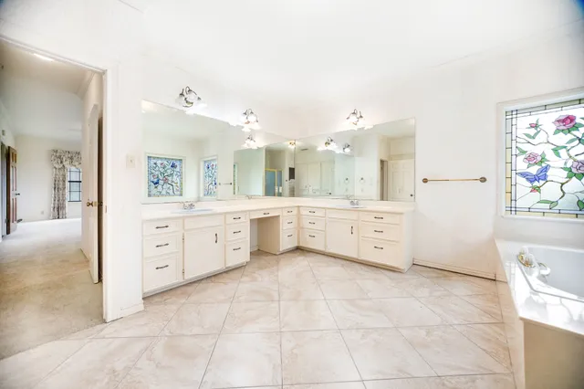 a spacious bathroom with a granite countertop sink mirror and bathtub