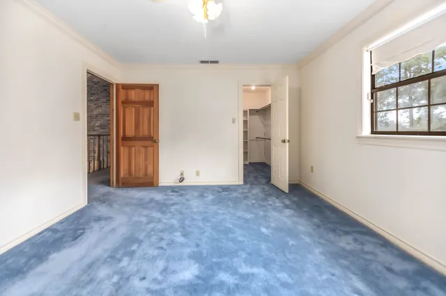 an empty room with windows and closet