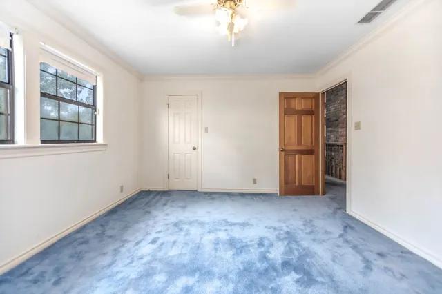 an empty room with windows and closet