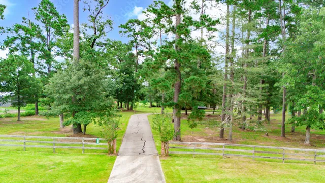 a swimming pool with lots of green space and trees in the background