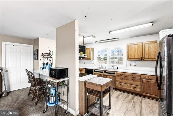 a kitchen with granite countertop cabinets stainless steel appliances a sink and a large window