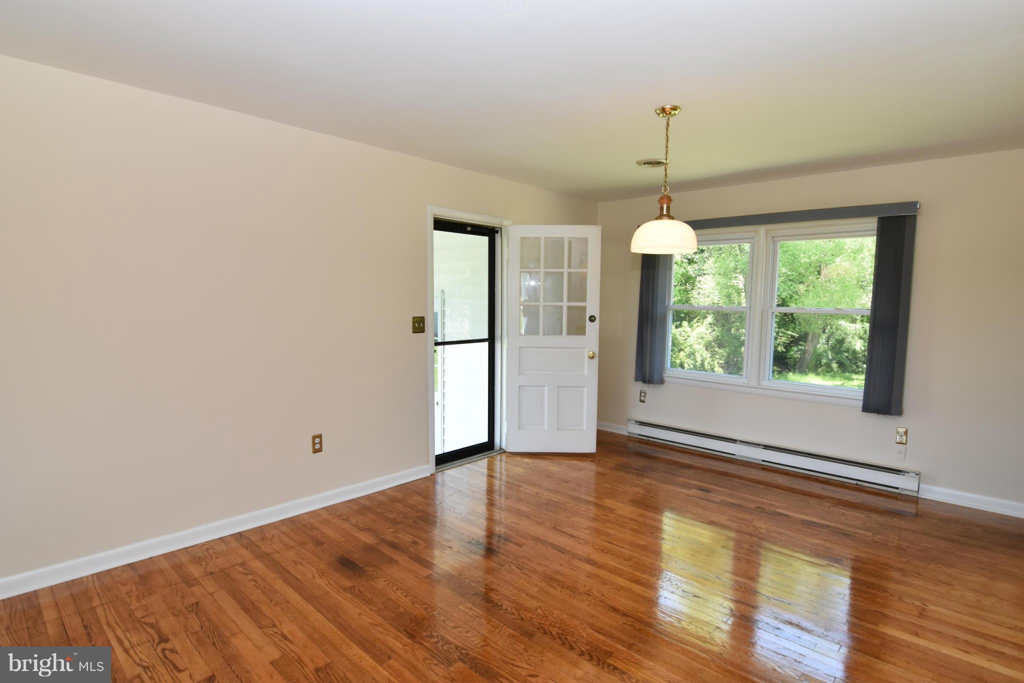 48632 Wynne Road Ridge, MD 20680 - Photo 2 of 30 a view of an empty room with wooden floor and a window