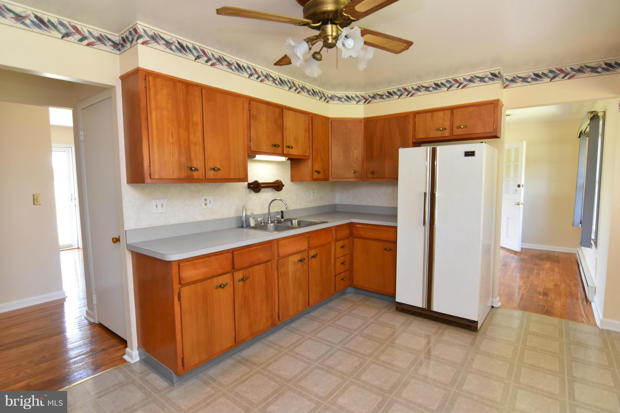 48632 Wynne Road Ridge, MD 20680 - Photo 12 of 30 a kitchen with stainless steel appliances granite countertop a refrigerator a sink dishwasher and white cabinets with wooden floor