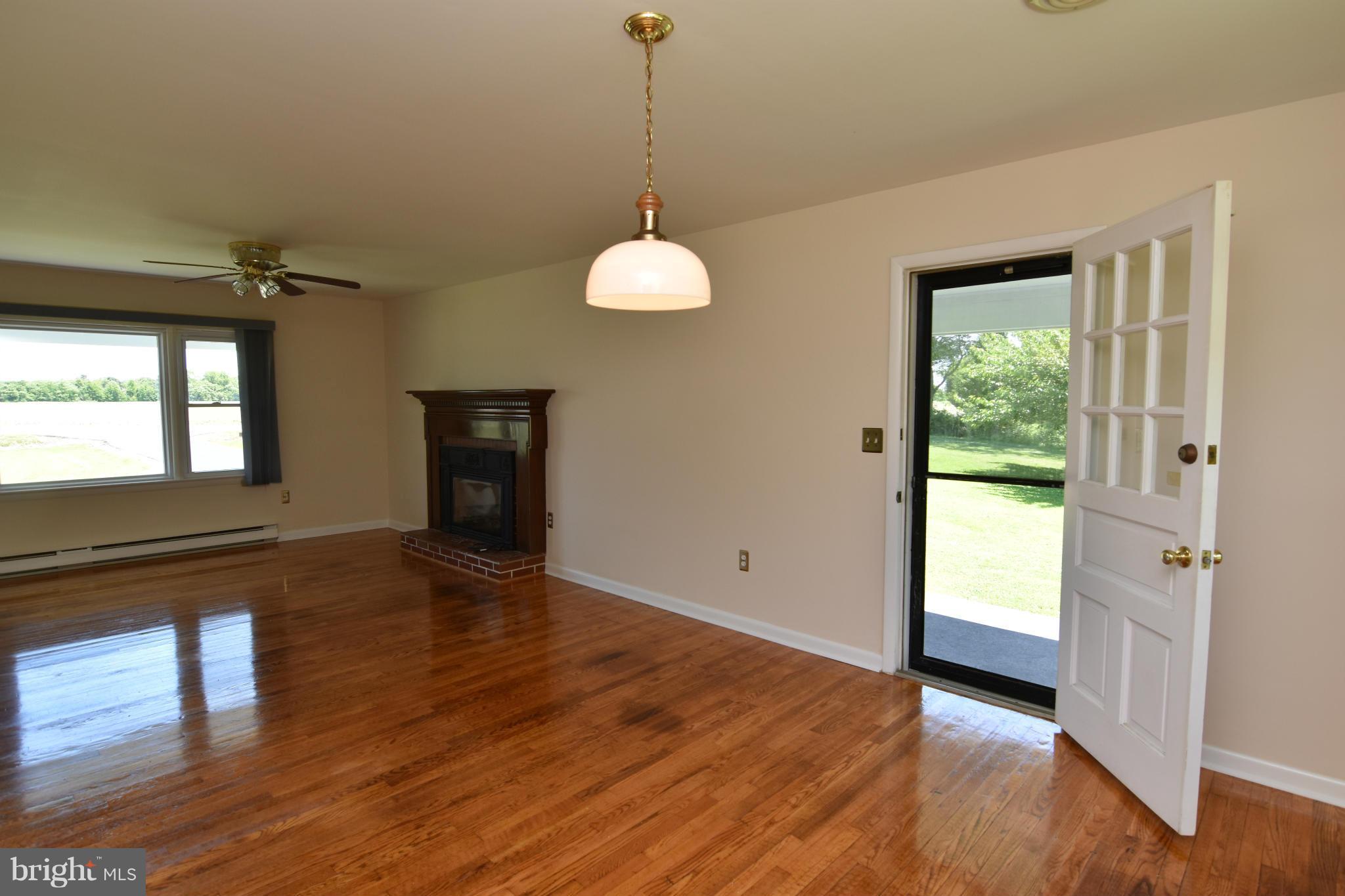 48632 Wynne Road Ridge, MD 20680 - Photo 3 of 30 a view of an empty room with wooden floor and a window