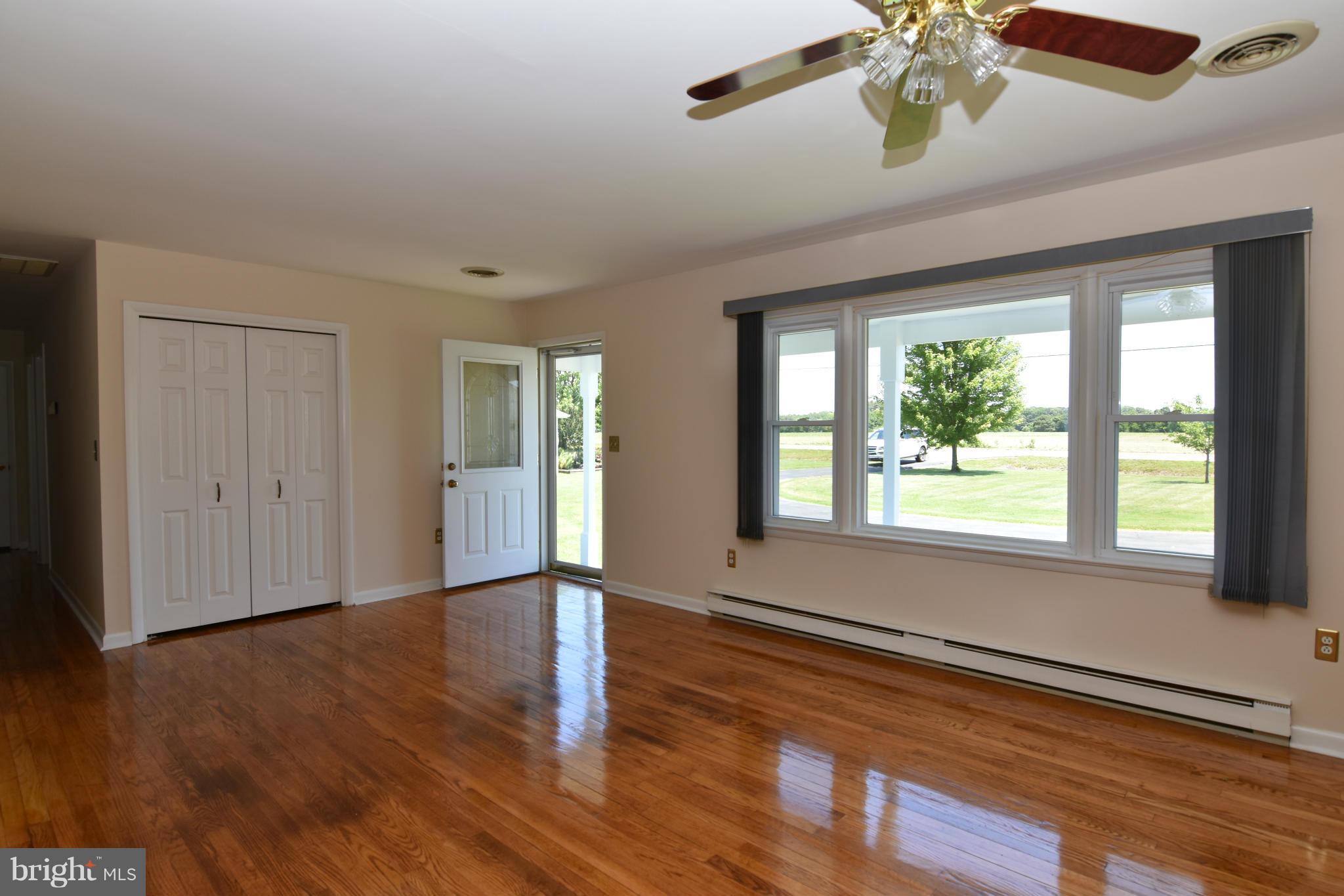 48632 Wynne Road Ridge, MD 20680 - Photo 6 of 30 a view of an empty room with wooden floor and a window