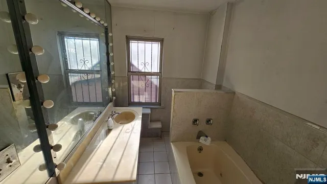 a bathroom with a tub sink and mirror
