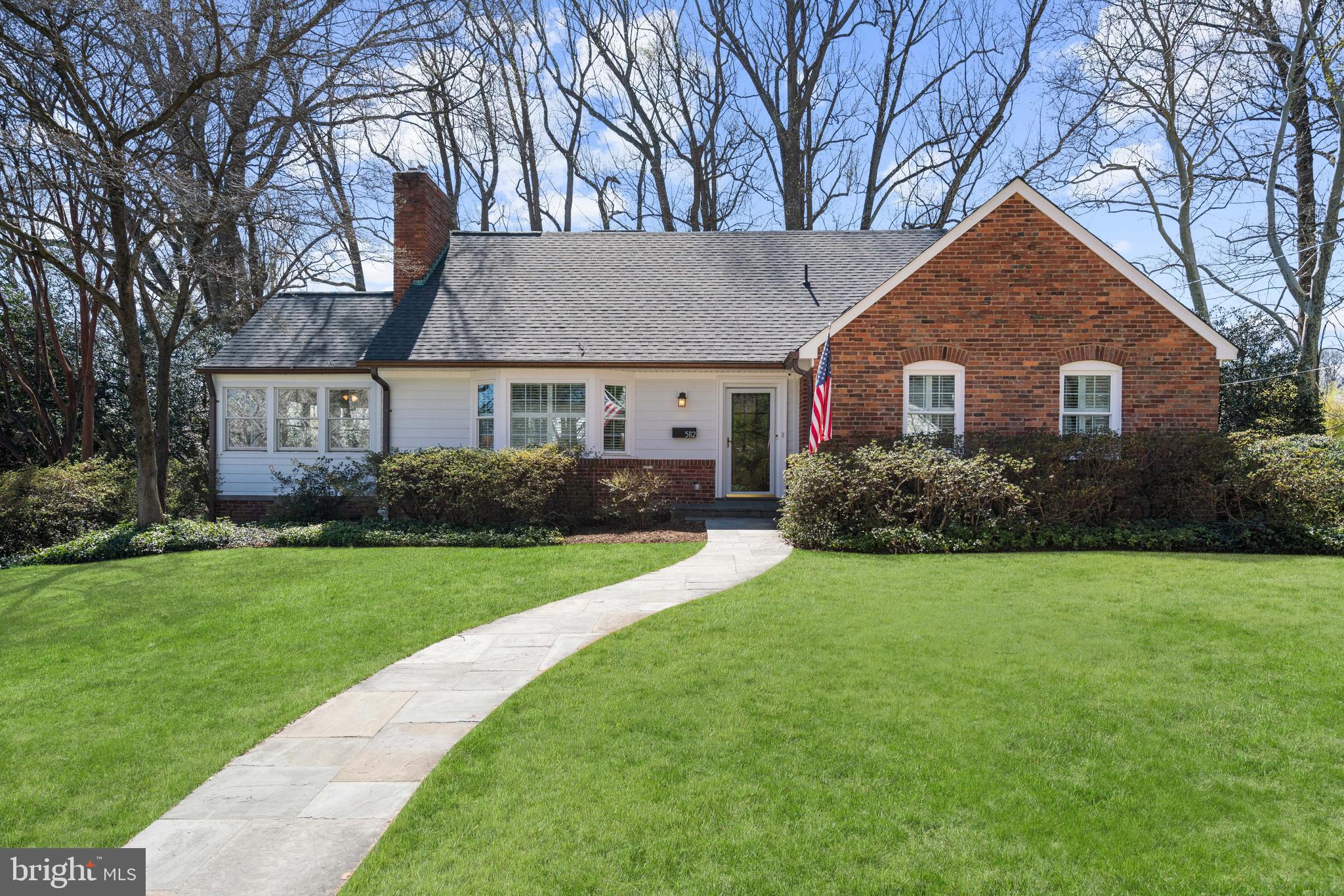 a front view of a house with yard and green space