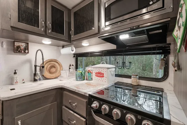 a view of kitchen with stainless steel appliances granite countertop a stove and a microwave