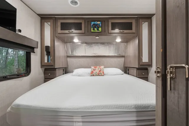 a bedroom with a bed and a mirror