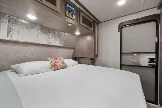 a bedroom with a bed and a flat screen tv