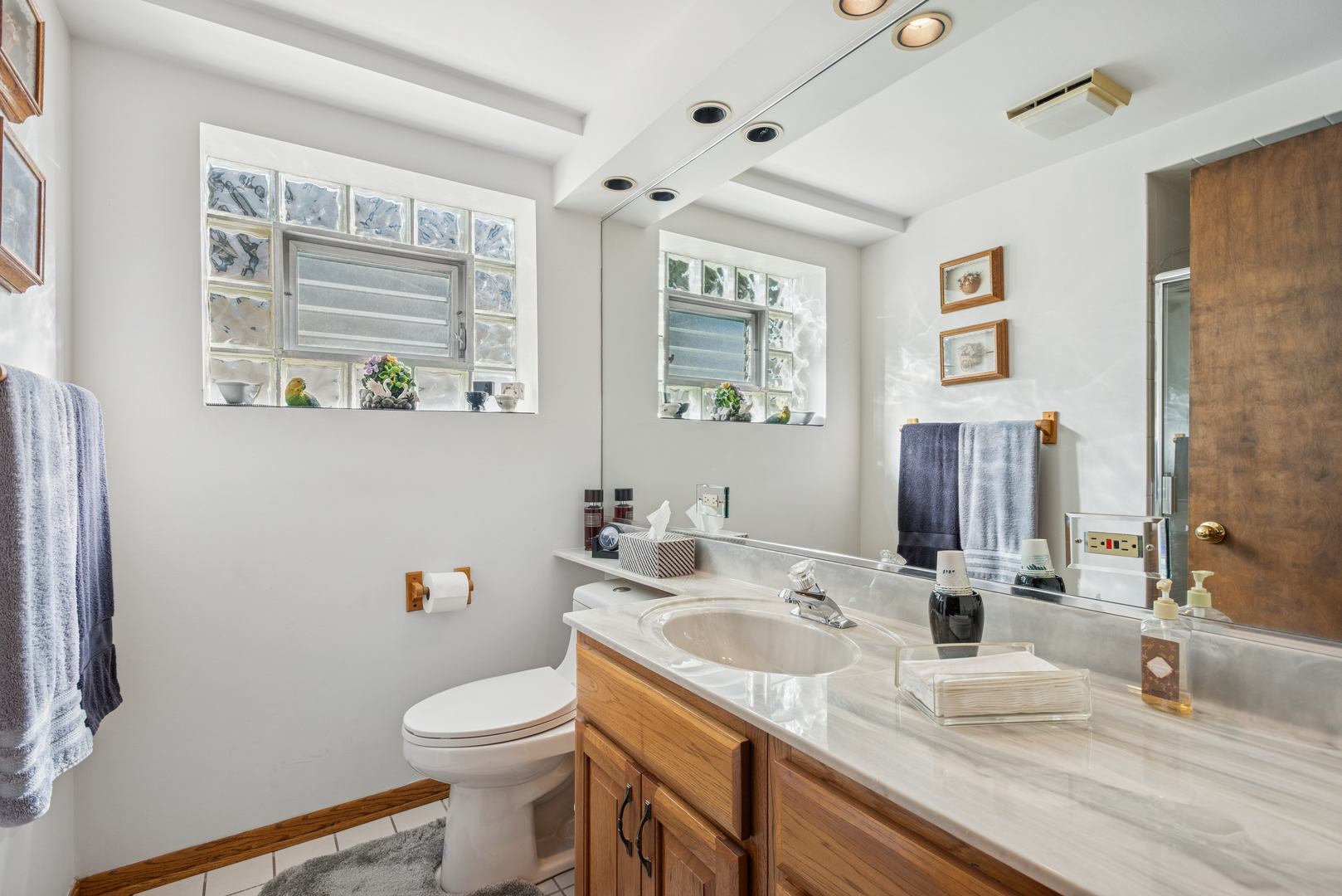 1725 Sycamore Street Des Plaines, IL 60018 - Photo 15 of 21 a bathroom with a granite countertop sink toilet and large mirror
