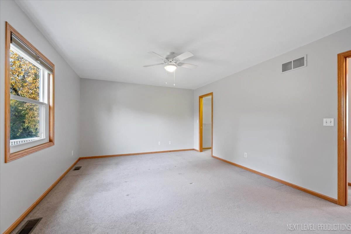 1146 Quail Run DeKalb, IL 60115 - Photo 14 of 31 an empty room with windows and fan