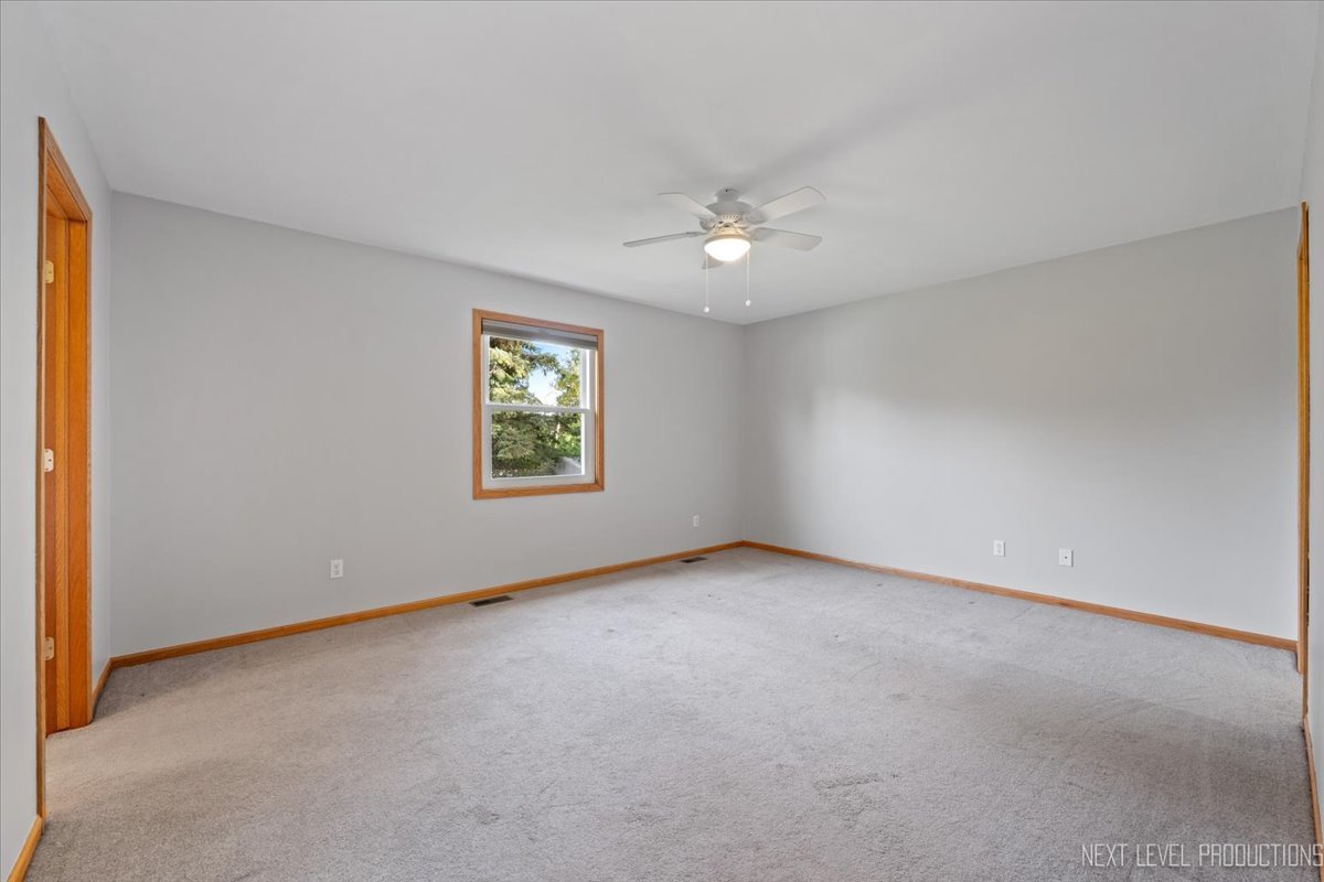 1146 Quail Run DeKalb, IL 60115 - Photo 16 of 31 an empty room with windows and chandelier fan