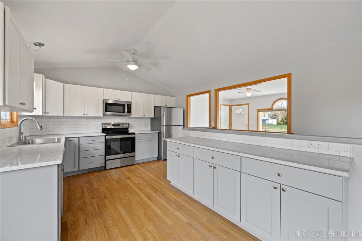 1146 Quail Run DeKalb, IL 60115 - Photo 7 of 31 a kitchen with granite countertop white cabinets and stainless steel appliances