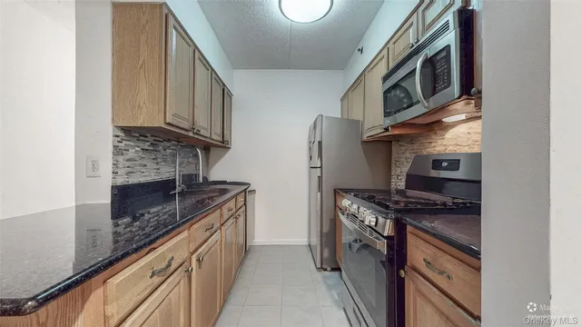 a kitchen with stainless steel appliances granite countertop a stove and a microwave